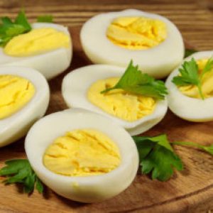 Boiled eggs with parsley on cutting board on a wooden table