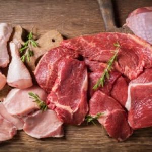 various types of fresh meat: pork, beef, turkey and chicken on a wooden table, top view